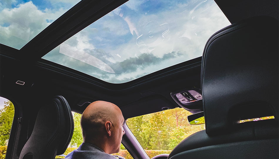 Vy inifrån vår XC60 Recharge med panoramaglastaket och himlen ovanför