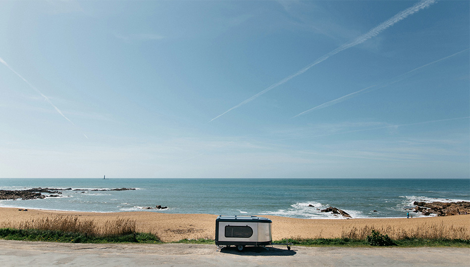 En pytteliten husvagn som står vid havet.