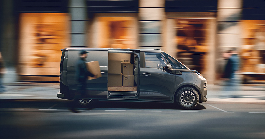 Renault Trafic E-Tech electric sidodörr öppen man ser paket inne i bilen och en man kommer och bär ett till paket